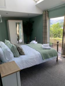 a bedroom with a large bed and a large window at Alt-an Retreat Lodge overlooking loch linnhe in Fort William