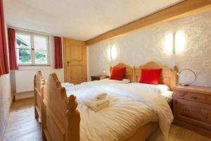 um quarto com uma cama grande e almofadas vermelhas em Ski- und Sommer-Chalet für 10 Personen in Dienten am Hochkönig em Dienten am Hochkönig