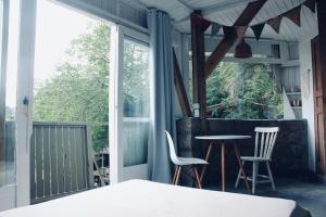 a bedroom with a balcony with a table and chairs at Casa Fluila in Praia do Rosa