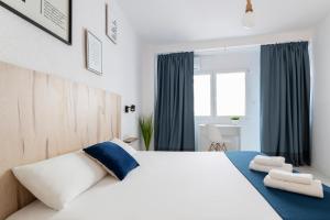 sypialnia z dużym białym łóżkiem z niebieskimi akcentami w obiekcie Casa M&J GuestHouse w Alicante