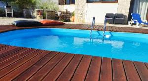 a large blue swimming pool on a wooden deck at Louro's Villa - 12130AL in Cantanhede