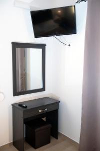 a vanity with a mirror and a tv on a wall at Apartments Kalaitzakis with private pool in Sitia