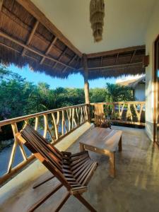 een veranda met 2 stoelen en een tafel op een balkon bij Aldea Balam in Tulum