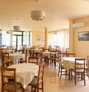 una sala da pranzo con tavoli e sedie con tovaglia bianca di Hotel Europa a Casal Velino