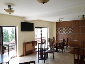 una sala da pranzo con tavoli e sedie e una TV a schermo piatto di Sport Avalanche a Ranca Altre 7 foto