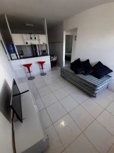 a living room with a couch and two red stools at Ap01-A 50 Metros da Praia Flats Mobiliados para 4 Pessoas in Paulista