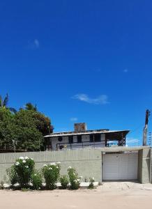 a building with two garage doors and a fence at Ap01-A 50 Metros da Praia Flats Mobiliados para 4 Pessoas in Paulista