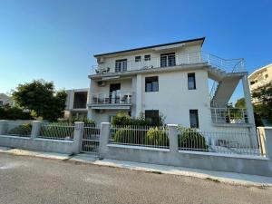 a white house with a fence in front of it at OSA Holiday in Ulcinj
