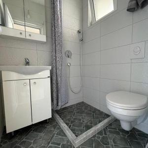 a bathroom with a toilet and a sink at OSA Holiday in Ulcinj +32 photos