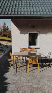 維斯瓦的住宿－Domki Ciszy Mi Daj，野餐桌、两把椅子、一张桌子和长凳