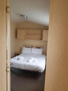 a bedroom with a bed with two towels on it at Hoburne Devon Holidays Park Sleep 6 Caravan in Paignton