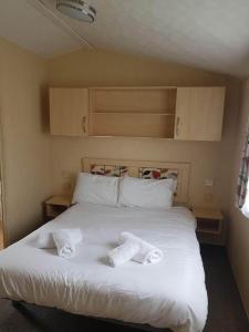 a bedroom with a bed with two towels on it at Hoburne Devon Holidays Park Sleep 6 Caravan in Paignton