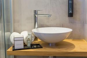 a bathroom with a white bowl sink on a counter at Hotel Alpin Tyrol - Kitzbüheler Alpen in Sankt Johann in Tirol