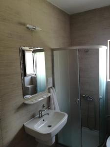 un bagno con lavandino, doccia e specchio di Sport Avalanche a Ranca