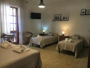 a room with three beds with towels on them at Mille Soli Bed and Breakfast in Buggerru