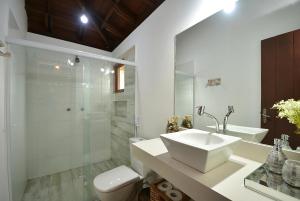 a bathroom with a sink and a toilet and a shower at Paraíso dos Guerreiros in Arraial d'Ajuda