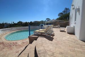a patio with two chairs and a swimming pool at Casa do Milho in Carvoeiro