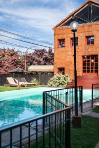 un edificio y una piscina frente a un edificio en Posada Alpenrose Neu, en Villa Carlos Paz