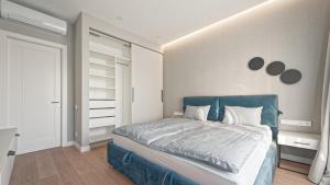 a bedroom with a bed with a blue headboard at Jūrmala, apartamenti Kruzes Nams in Jūrmala