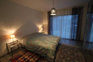 - une chambre avec un lit, deux lampes et un tapis dans l'établissement Amour Périgord, à Montignac