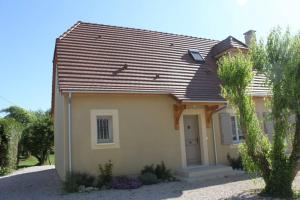 une petite maison jaune avec un toit brun dans l'établissement Amour Périgord, à Montignac