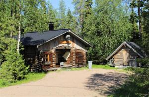 a log cabin in the woods with a driveway at Logwood Villa Restamaja in Luosto