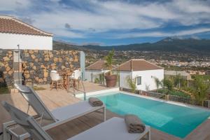 a villa with a swimming pool and a patio at Villas Taburiente in Los Llanos de Aridane