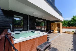 a jacuzzi tub on the patio of a house at Mariah Spa Deluxe Apartment in SILVER MOUNTAIN in Poiana Brasov