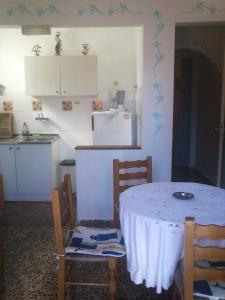 a kitchen with a table and chairs and a refrigerator at Magdalini in Votsi