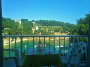 a table on a balcony with a view of the beach at Magdalini in Votsi