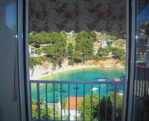 a view of a beach from a window at Magdalini in Votsi