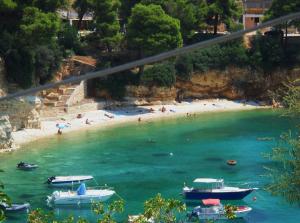 a beach with boats and people in the water at Magdalini in Votsi