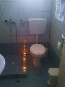 a bathroom with a toilet and a shower with lights at Magdalini in Votsi