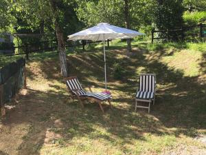 dwa krzesła i parasol na dziedzińcu w obiekcie A casa di Andre’ w mieście Vara Superiore