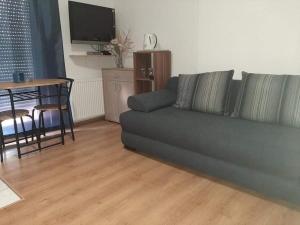 a living room with a green couch and a table at Apartmani Vodice I in Vodice