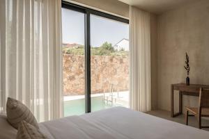 a bedroom with a bed and a large window at Seven Rocks in Paliouri