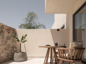 a patio with a table and chairs and a plant at Seven Rocks in Paliouri