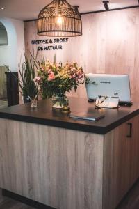 a counter with a laptop and flowers on it at Witte Berken Natuurhotel in Epe