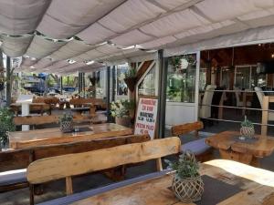 a restaurant with wooden benches and tables in front at Apartmani Vodice I in Vodice