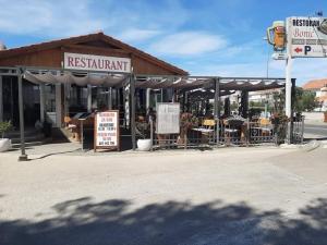 a restaurant with tables and chairs in front of a building at Apartmani Bonić in Vodice