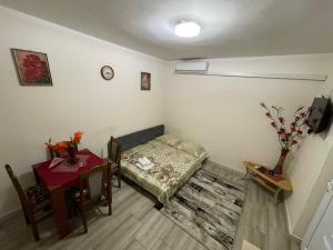 a small room with a bed and a table at Apartmani Miro Trebinje in Trebinje