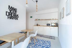 a kitchen with white cabinets and a wooden table at HB ROOMS - Casa M&J Guest House in Alicante