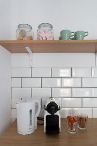 a kitchen counter with a coffee maker and a toaster at Casa M&J GuestHouse in Alicante