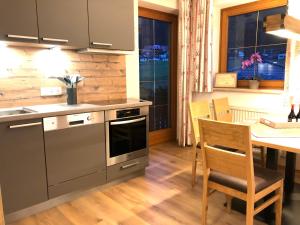 a kitchen with a table and a stove top oven at Veronika Appartements in Sankt Jakob in Defereggen