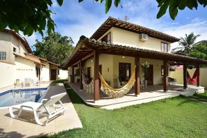 een huis met een hangmat naast een zwembad bij Paraiso do Sol in Arraial d'Ajuda