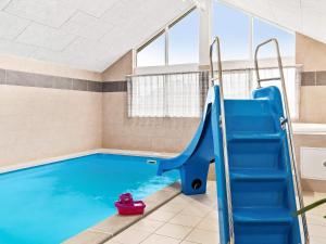 a swimming pool with a blue pool slide in a room at 18 person holiday home in Hasselberg in Kappeln