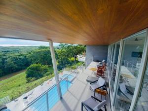 a house with a balcony with a pool and chairs at Casa Paraiso Azul Ocean View in Camaronal