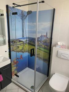 a bathroom with a shower with a painting of a castle at Pension Triebischtal in Meißen