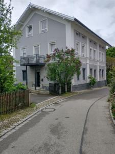 ein weißes Gebäude mit Balkon auf einer Straße in der Unterkunft Bad Aibling City Apartment DG in Bad Aibling