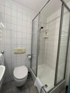 La salle de bains est pourvue d'une douche, de toilettes et d'un lavabo. dans l'établissement Pension am Meer, à Norddeich